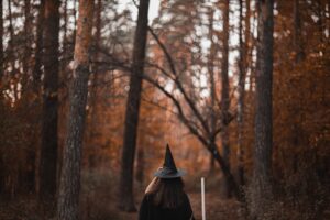 person in black hat standing in forest